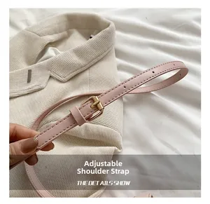 Detailed view of adjustable pink faux leather shoulder strap with gold-tone metal buckle