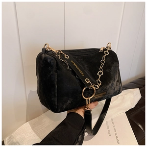 Detail of black velvet Boston bag showing gold flower chain and fashion strap