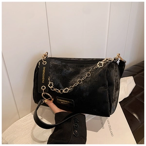 Detail of black velvet Boston bag showing gold floral chain and BEIKAMU brand metal logo