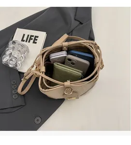 Top view of beige bucket bag showing spacious interior with woven texture and a wallet
