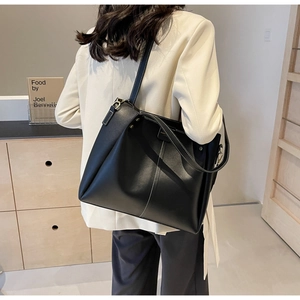 Gros plan du grand sac cabas en cuir noir avec surpiqûres blanches contrastées et bandoulière