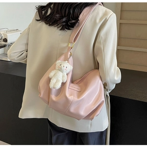 Pink pleated tote bag with plush bear charm showing wide adjustable shoulder strap detail
