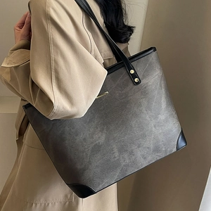 Minimalist large-capacity washed canvas tote bag with black leather trim and gold rivets