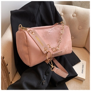 Detailed close-up of pink velvet Boston bag with gold floral chain and designer strap