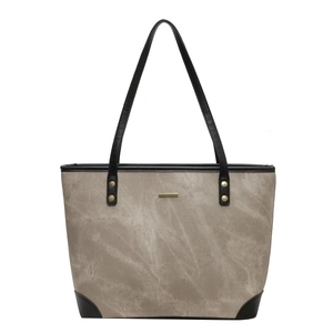 Minimalist grey canvas tote bag with black leather trim and gold metal accents