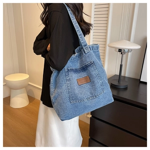 Sac fourre-tout en jean bleu avec poche latérale et étiquette en cuir en intérieur