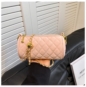 Close-up of pink quilted velvet cylinder bag with gold chain strap and bead detail