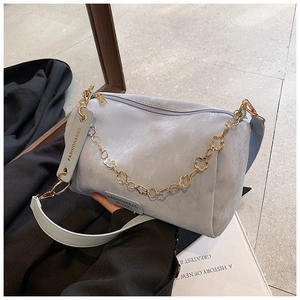 Detail of light blue Boston bag with gold flower chain and soft suede texture