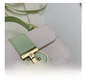 Close-up of pink faux leather bag with crocodile pattern and golden metal buckle