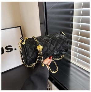 Detailed close-up of the quilted leather cylinder bag with gold chain strap and bead adjustor