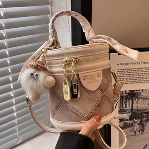 Beige cylindrical bucket bag with leather patchwork and decorative checkered silk scarf