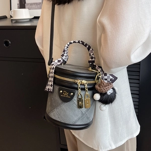 Quilted grey and black bucket bag with silk scarf handle and pompom charm