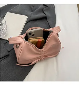 Pink pleated handbag interior showing capacity for smartphone, wallet and lipstick