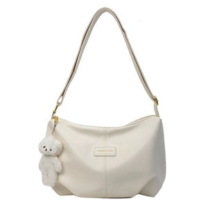 Chic cream white pleated crescent tote bag with an adorable plush bear charm