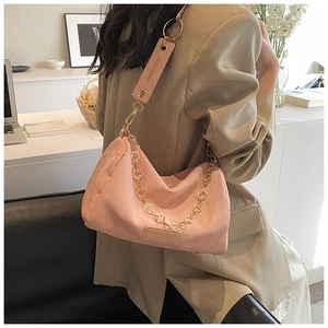 Detailed view of a pink pleated Boston bag with floral gold chain and brand tag