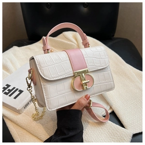 Close-up of white croc-embossed leather texture and pink contrast flap on hand-held bag