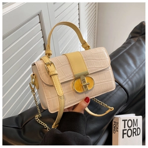 Detail of croc-embossed small square bag with yellow strap and gold metal buckle
