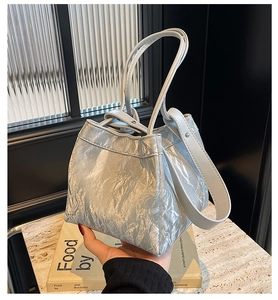 Detail of silver-blue wrinkled texture tote bag with dual handles and smooth leather strap