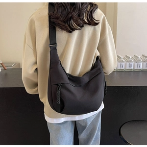 Rear view of a large black nylon dumpling bag with an adjustable wide shoulder strap