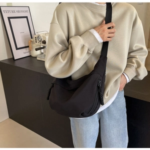 Detail of a large capacity black nylon crescent bag with adjustable shoulder strap