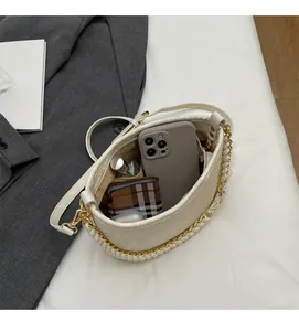 Internal view of a white leather bucket bag showing capacity for phone and wallet
