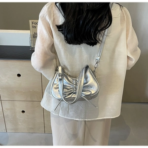 Detailed view of silver pleated crossbody bag with long tassel and metallic PU finish