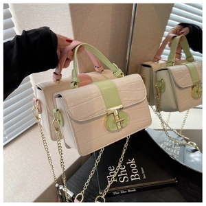Detail of color-block crocodile pattern bag with gold chain and metal twist lock