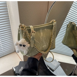 Detail of light green marble texture bucket bag with gold chain and plush monster charm