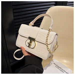 Detail of white crocodile pattern small square bag with golden T-shaped metal clasp