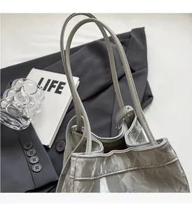 Detail of silver gray pleated bucket bag with metallic luster on suit background