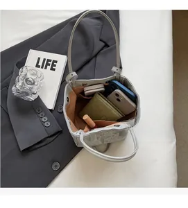 Top view of the spacious inner compartment of the light gray textured leather bucket bag