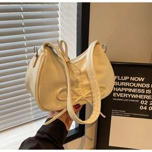 Detail of cream pleated shoulder bag with bow knot decoration and soft leather texture