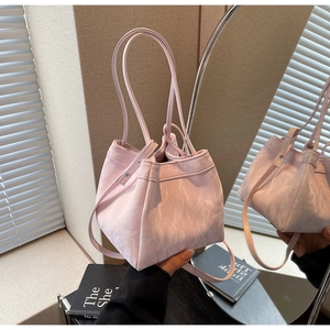 Detail of lavender bucket bag with artistic pleated texture and adjustable strap