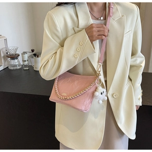 Pink pleated leather bucket bag with metal chain detail and white fluffy charm accessory