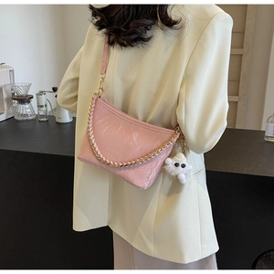 Pink marble pattern bucket bag with gold chain and plush charm detail on a model