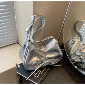 Detail of silver metallic wrinkled texture with bow accents and zipper closure