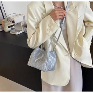Detail of light blue pleated drawstring bucket bag with metallic texture finish