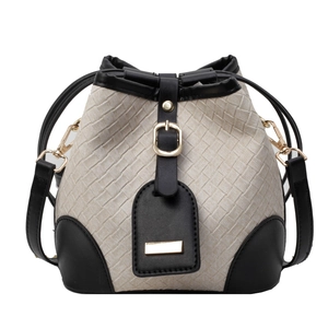 Minimalist woven bucket bag in beige and black with adjustable leather strap