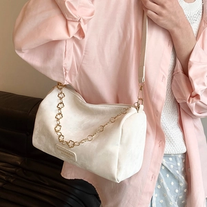 White cylindrical Boston shoulder bag with golden floral chain and soft matte finish