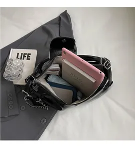 Vista interna della borsa tote nera lucida che mostra la grande capacità per tablet e libri
