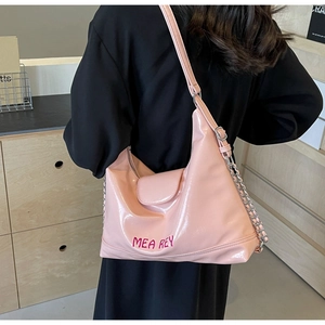 Dettaglio della borsa rosa in pelle lucida con catena argento e ricamo del logo rosso
