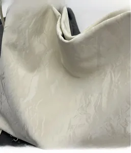 Close-up of the lightweight pleated fabric with natural texture on this beige tote bag
