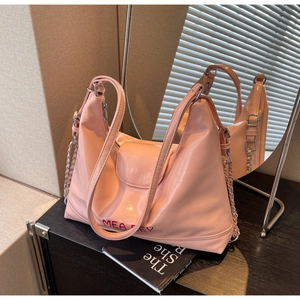 Dettaglio della borsa tote in pelle rosa con catene metalliche e ricamo MEA BEY