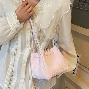 Pink marbled bucket bag with dual straps worn by a model in a minimal interior setting