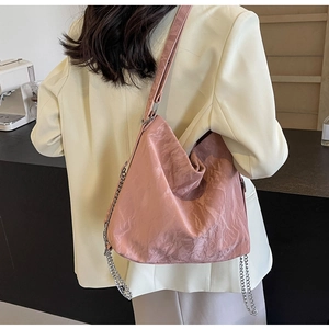 Detail of pink pleated tote bag with silver chain strap worn with casual blazer