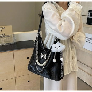 Détail du sac cabas en velours noir avec chaîne de perles et breloque nuage en peluche