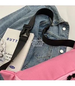 Dettaglio della borsa a tracolla in tela a righe rosa con spallaccio regolabile in nylon nero