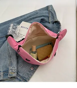 Spazio interno della borsa a tracolla in velluto a coste rosa con oggetti personali