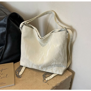 Detail of creamy white hobo bag showing pleated texture and multi-functional shoulder strap