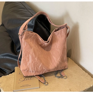 Detail of dusty pink tote bag showing vintage crinkled texture and metal chain accents